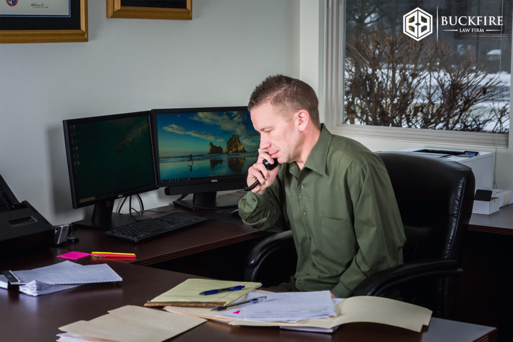 Michigan assault and battery attorney on the phone at his desk